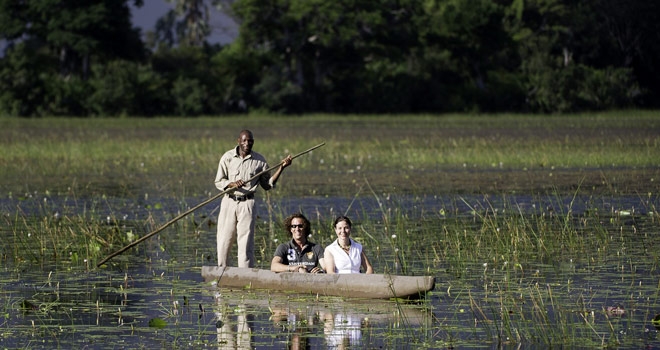 Guide and guests Mokoro boating at Kwetsani Camp, Okavango Delta, Botswana