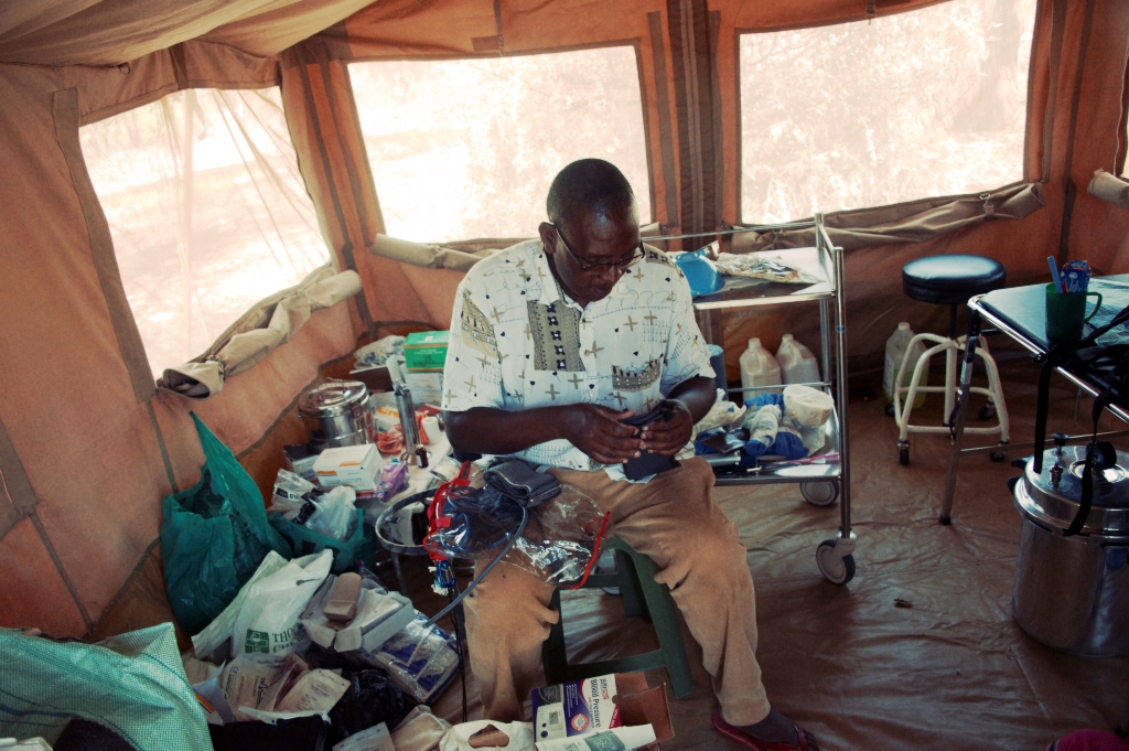 Medical member of staff in a mobile eye care tent surrounded by medical supplies