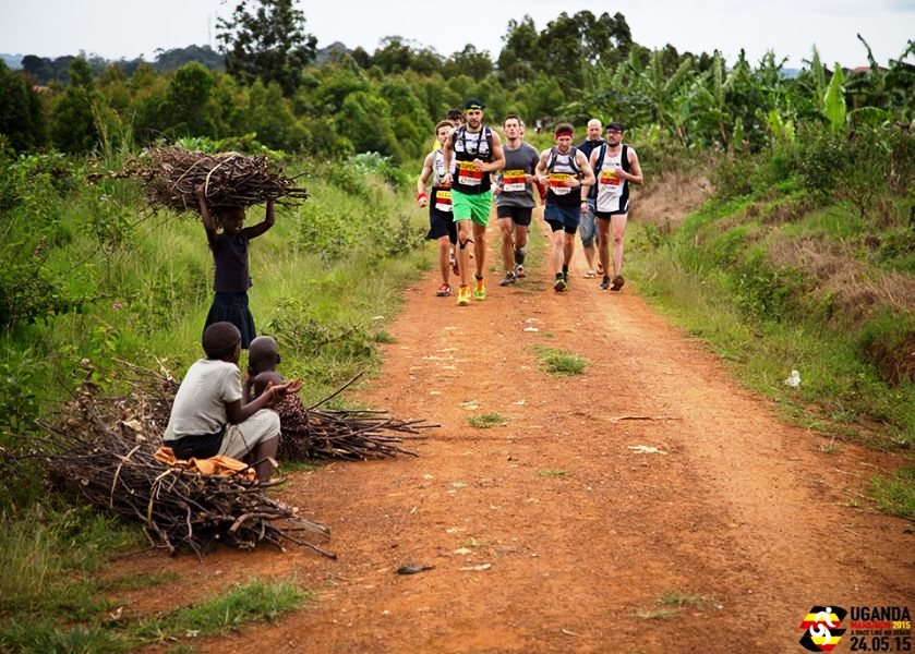Uganda Marathon runners and children with firewood, photographer Peter Wilson