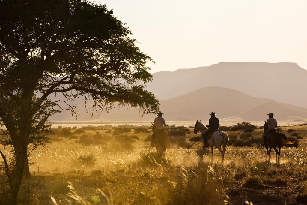 riders in the sunshine Desert Homestead, Sossusvlei, Namibia
