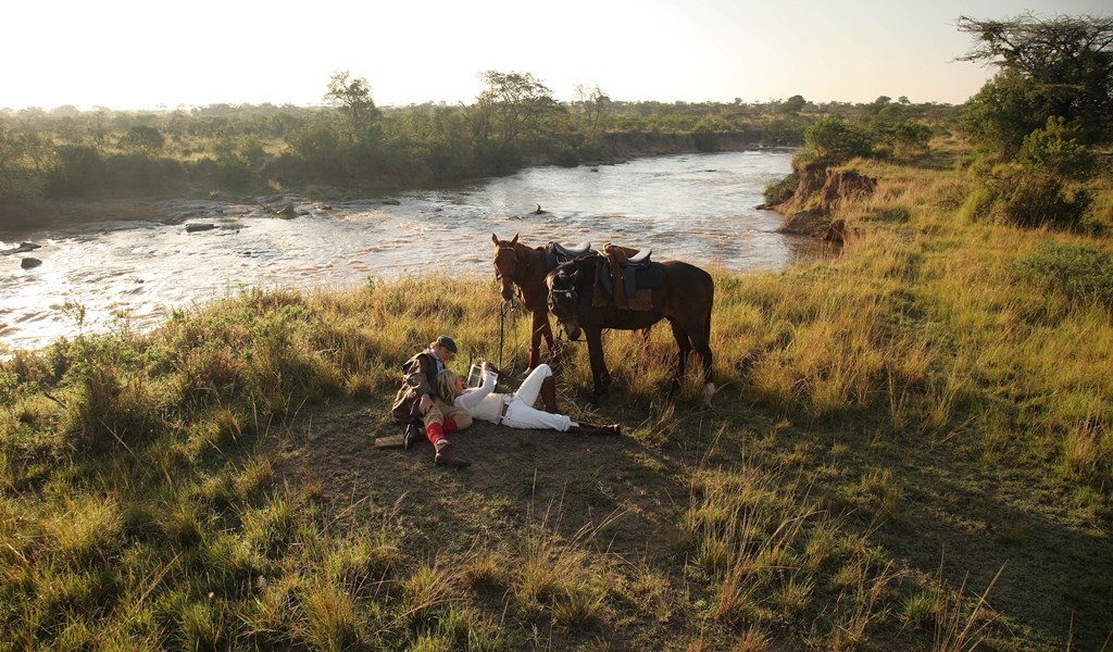 A romantic couple by the river with their horses, Safaris Unlimited Kenya