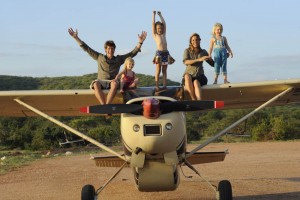 Saba and family sitting on husband Frank's plane at Elephant Watch Camp front of plane