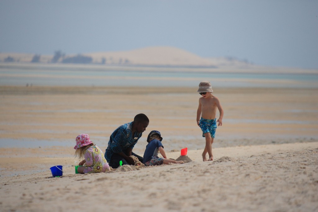 Children and sitter playing on the beaches at Azura, Benguerra, Mozambique