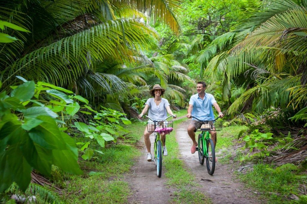 romantic couple on mountain bikes Desroches Island, Seychelles