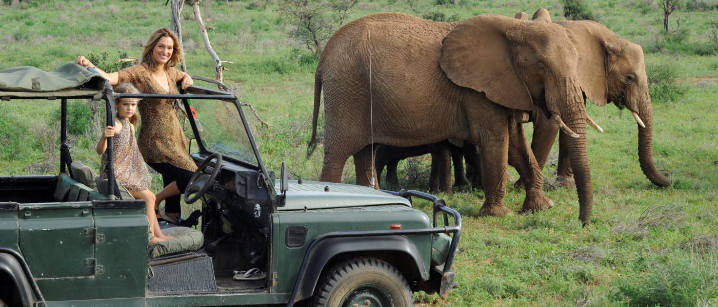 Saba Doulgas Hamilton with daughter in safari vehicle with elephant herd