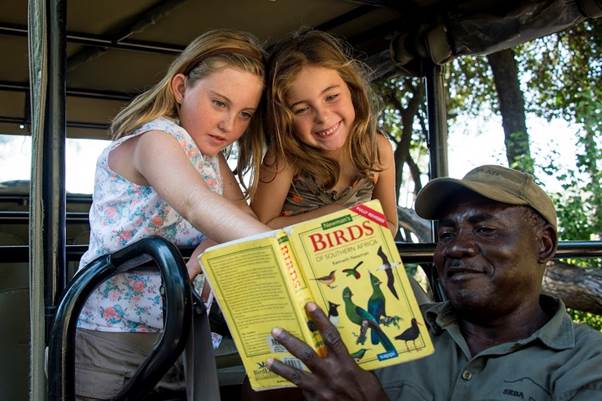 Seba Camp two girls learning about birds with guide Okavango delta Botswana