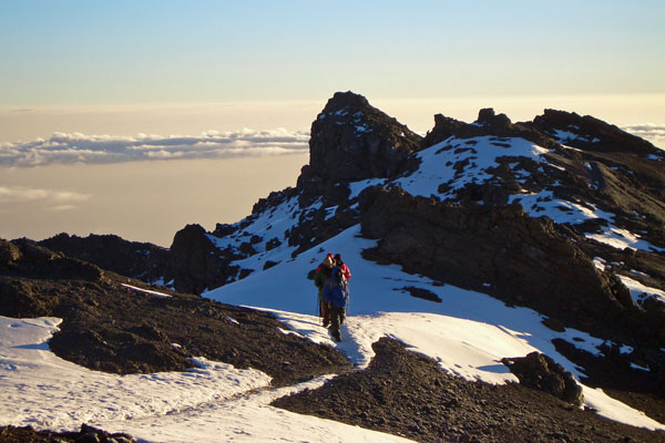 Trekkers nearing the icy summit climbing Mount Kilimanjaro