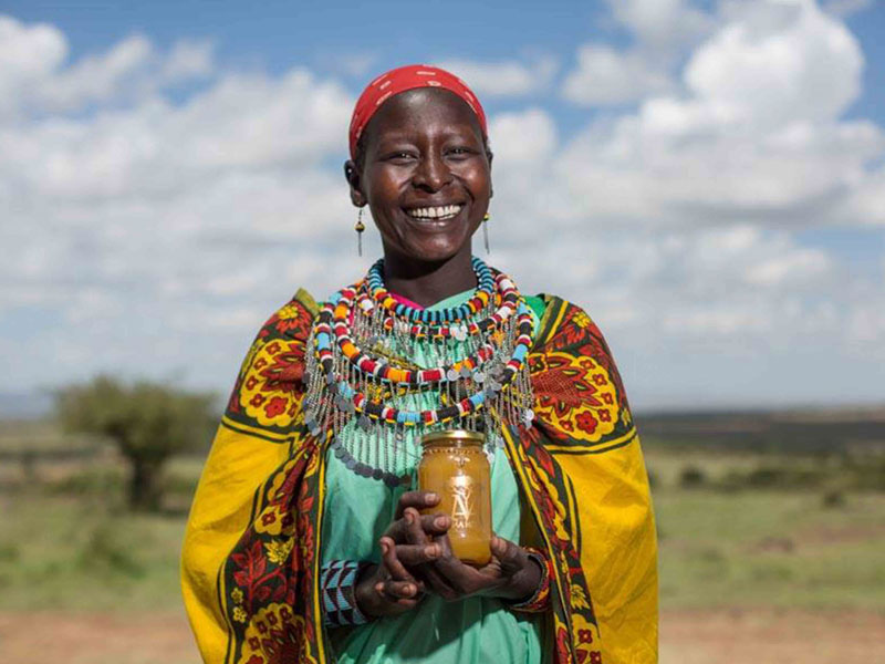 Maa Trust African lady holding jar of honey