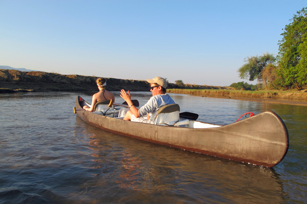 Teenagers canoeing on a tranquil channel of the Chongwe River family safari experiences 
