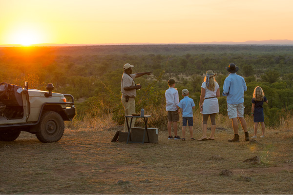 Family watching the sundown with guide after a safari Luangwa Safari House family safari experiences 