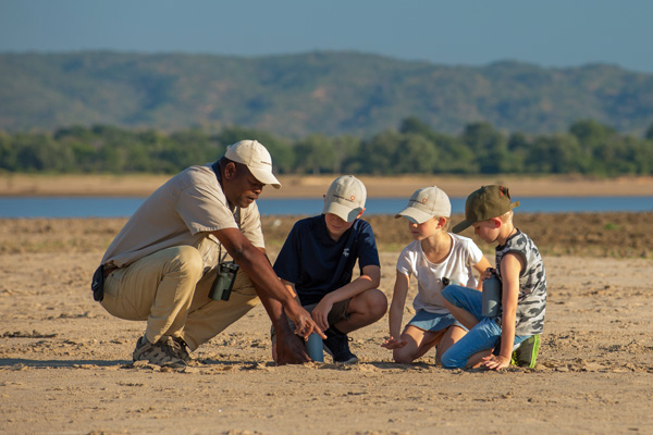 Guide and children looking an tracks and spoor family safari experiences 