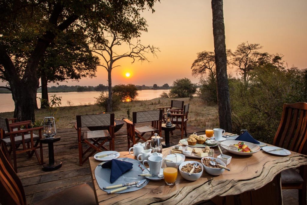 Mpala Jena Camp private dining by the Zambezi at sunset